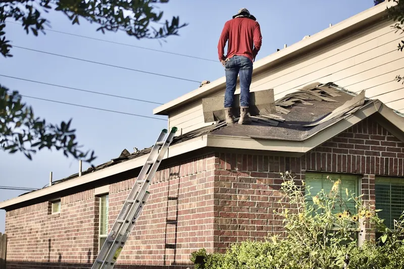 Professional roofer working on a residential roof in Orchard Place
